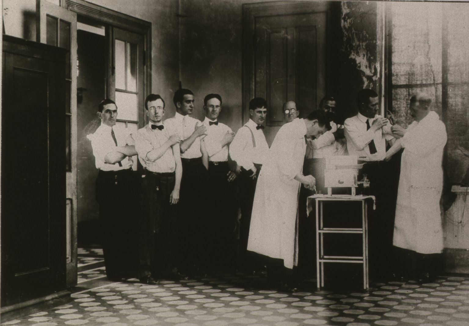 Historical photo of men lined up to receive typhoid vaccine