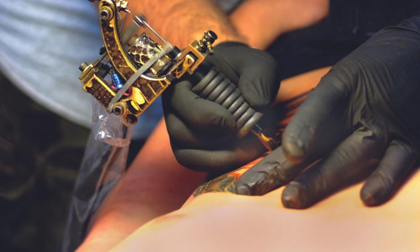 Close up of tattoo gun on skin